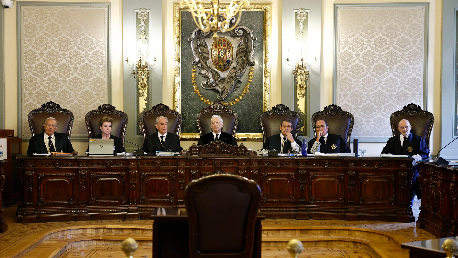 Sala de un tribunal durante una sesión institucional, con magistrados sentados ante una mesa presidencial.